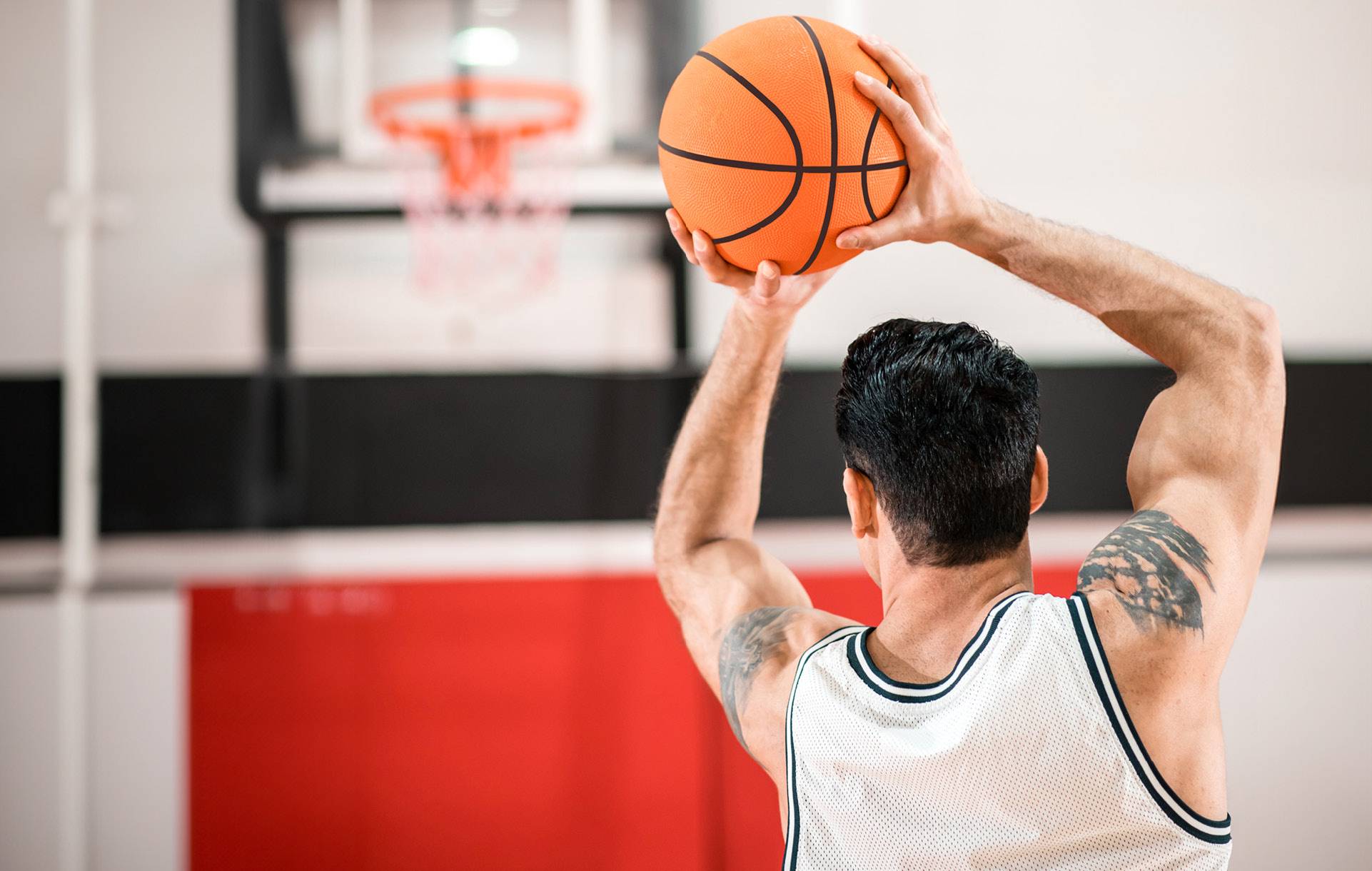 Foto di una persona giovane che ha completato il recupero post-operatorio dopo una lussazione di spalla e riprende a giocare a basket